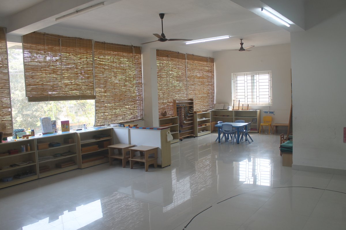 Spacious Kidoz Montessori classroom with child-sized furniture, Montessori materials on open shelves, and natural light