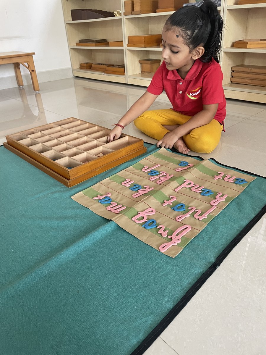 Girl forming words with Montessori moveable alphabet letters