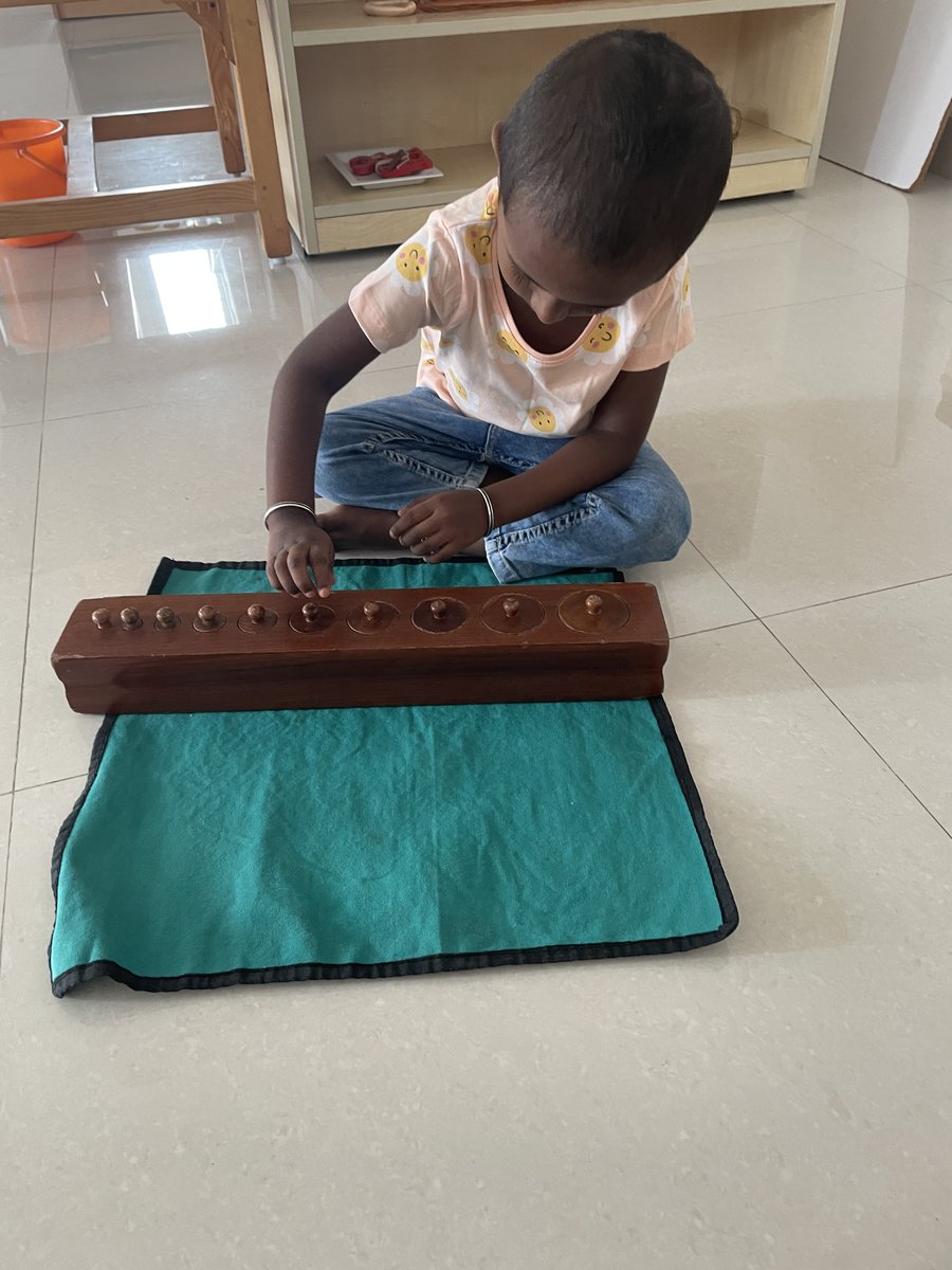 Child working with Montessori knobbed cylinders